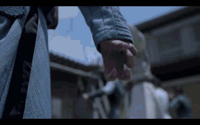 a person holding another person 's hand in front of a group of people