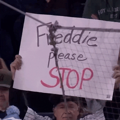 a man is holding up a sign that says freddie please stop