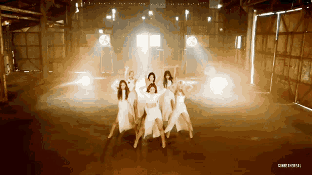 a group of women are dancing in a dark room with smoke coming out of the doors