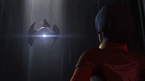 a woman stands in front of a space ship with a light shining on it