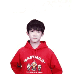 a young man wearing a red baby milo hoodie is holding a balloon in his hand .