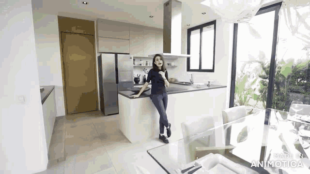 a woman is standing in a kitchen next to a table with the word animatica on it