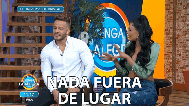 a man and a woman sitting in front of a sign that says el universo de kristal