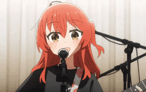 a girl with red hair is singing into a microphone while holding a guitar