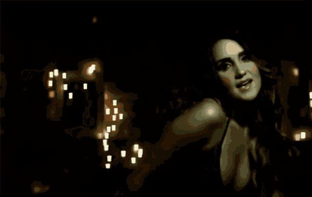 a woman in a black top is looking at the camera