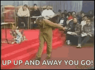 a man is dancing on a red carpet in front of a crowd of people .