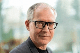 a close up of a man wearing glasses and a suit .