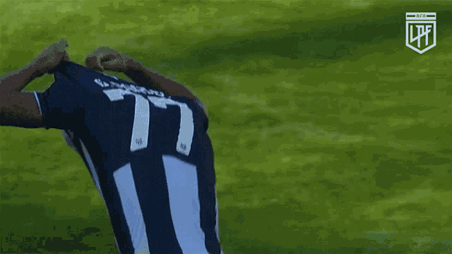 a soccer player wearing a number 11 jersey stands on a field