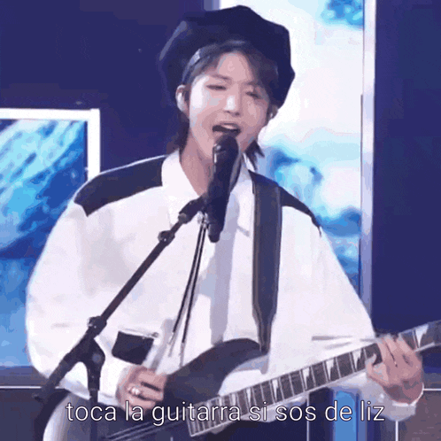 a person playing a guitar and singing into a microphone