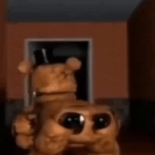 a teddy bear is standing in a dark room with a door in the background .