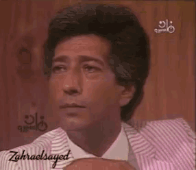 a man in a pink and white striped suit and tie has the name zahraelsayed on the bottom