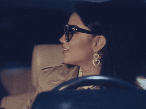 a woman wearing heart shaped earrings is smiling