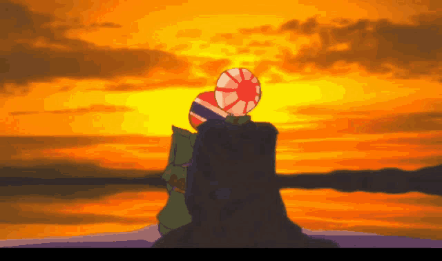 a couple sitting on a rock watching a sunset with flags on their heads