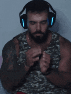 a man with a beard is wearing headphones and a camouflage tank top
