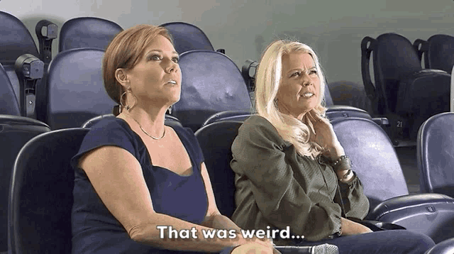 two women are sitting in a stadium with the words that was weird