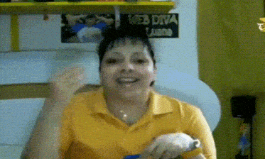 a woman in a yellow shirt is smiling in front of a sign that reads web diva