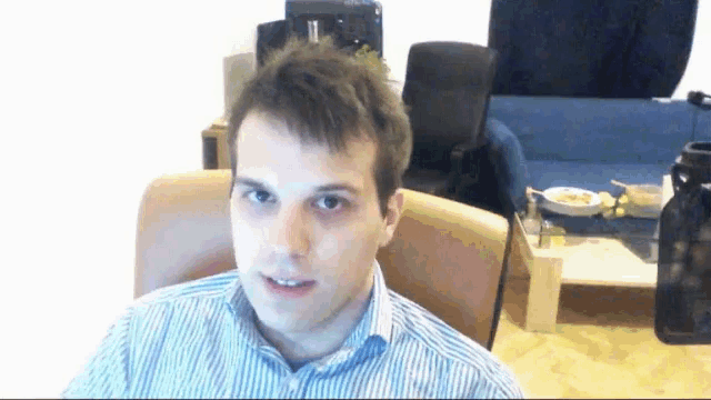 a man in a striped shirt sitting in a chair