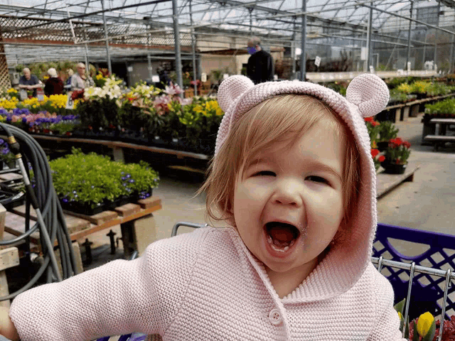 a little girl wearing a teddy bear hooded jacket with ears
