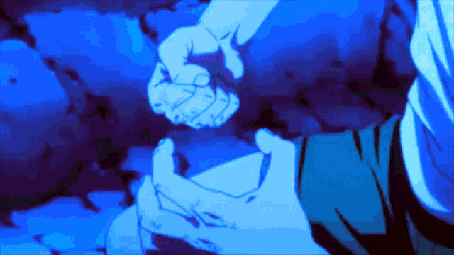 a person is holding another person 's hand in a blue light