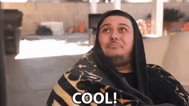 a man wrapped in a blanket with the word cool on the bottom right