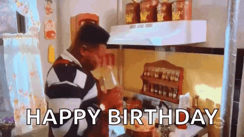 a man is drinking from a cup in a kitchen and the words `` happy birthday '' are written below him .
