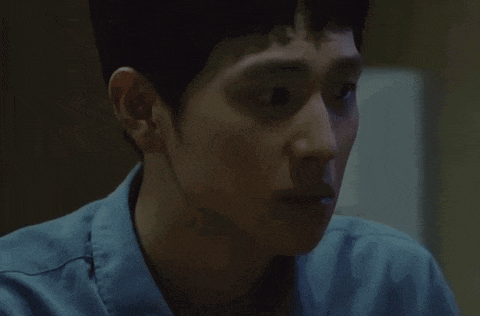 a close up of a man 's face with a blue shirt on