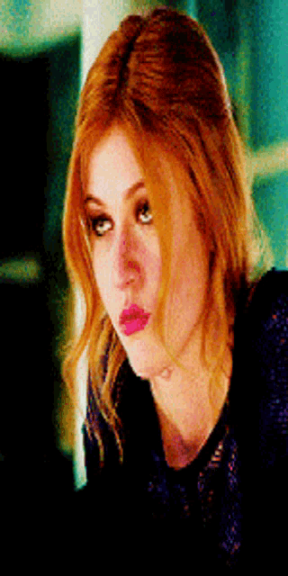 a close up of a woman 's face with red hair and pink lips .