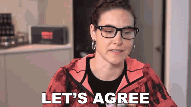 a woman wearing glasses and a red jacket is saying let 's agree