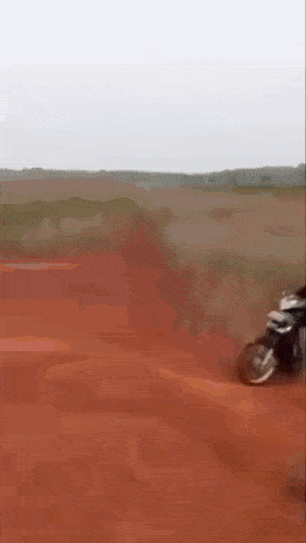 a person is riding a motorcycle on a dirt road in the desert .
