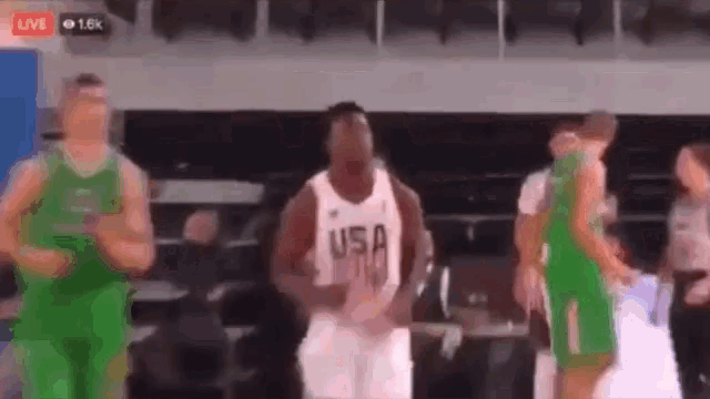 a basketball player wearing a usa jersey is dancing on a court .