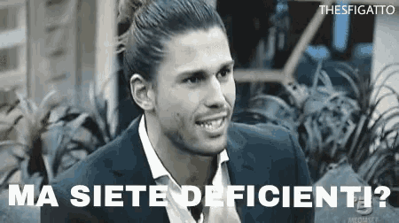 a man in a suit and tie is smiling in a black and white photo with the words ma siete deficienti written above him .