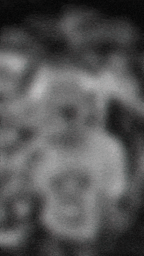 a black and white photo of a blurred background with a few spots of light on it .