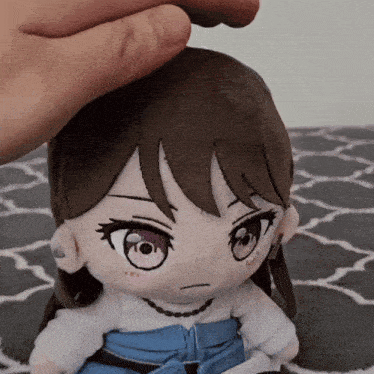 a person is putting their hand on a stuffed doll