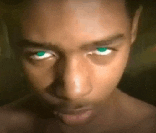 a close up of a man 's face with green eyes looking at the camera .