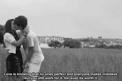 a man and a woman are kissing in a field with a quote .