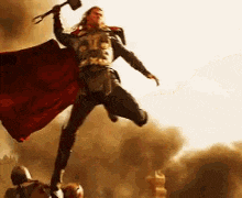 thor is flying through the air holding a hammer in his hand .