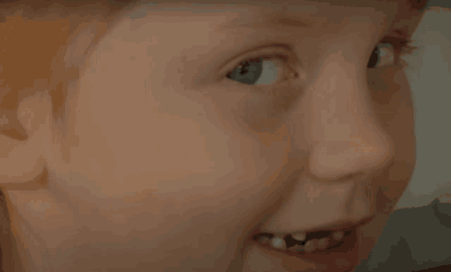 a close up of a child 's face with a few teeth missing
