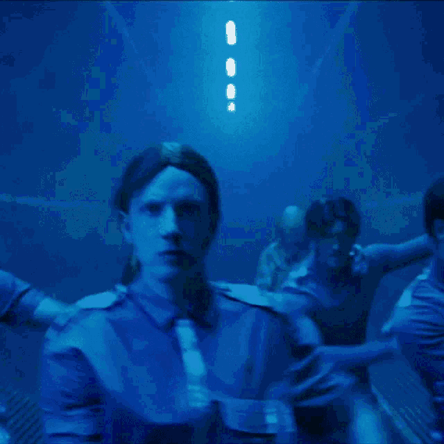 a man in a blue shirt holds his arm up