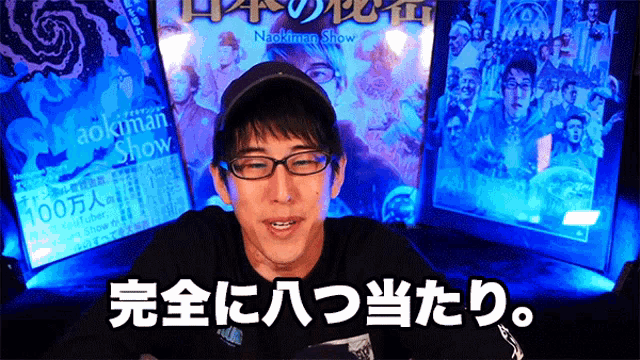 a man wearing glasses and a hat stands in front of a sign that says aokiman show