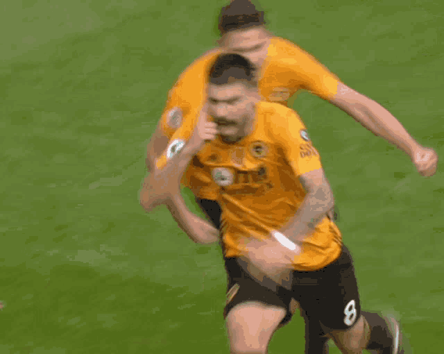 a soccer player wearing a yellow jersey that says wolves