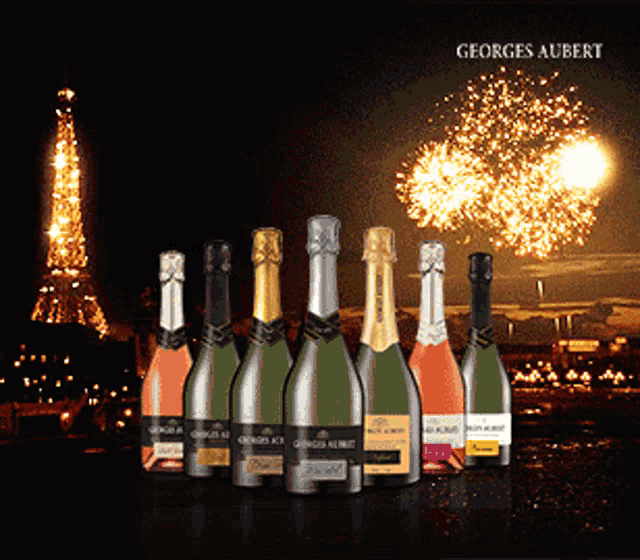 several bottles of georges albert champagne are lined up in front of fireworks