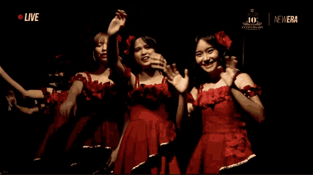 a group of women in red dresses are dancing in front of a new era logo