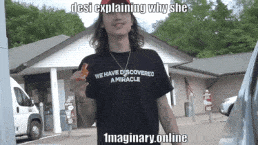 a man wearing a black t-shirt that says we have discovered a miracle
