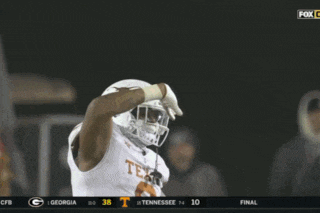 a football player in a tennessee uniform waves his hand in the air