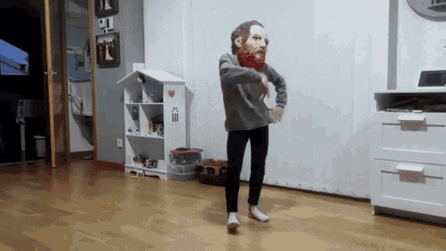 a child wearing a bearded mask is dancing in a room