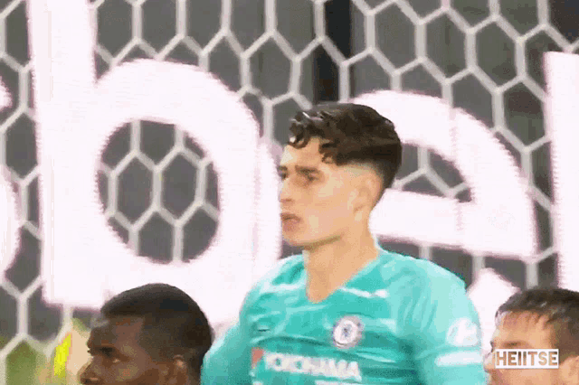 a soccer player wearing a yokohama jersey stands in front of a goal
