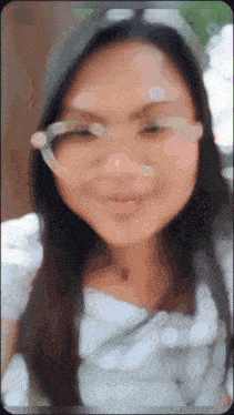 a blurry photo of a woman wearing glasses and a hat