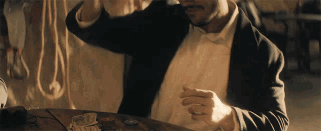 a man in a tuxedo is sitting at a table
