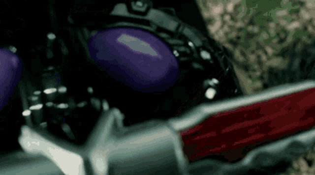 a close up of a toy with purple eyes and a red blade .