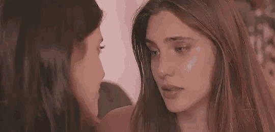 two women are looking at each other with their eyes closed and their mouths open .